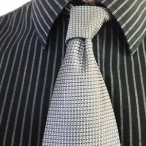 A close-up view of a tie paired with a black and white striped shirt, showcasing the fabric's texture and pattern.