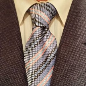 A close-up of a man in a formal suit and tie, showcasing a professional and polished appearance.