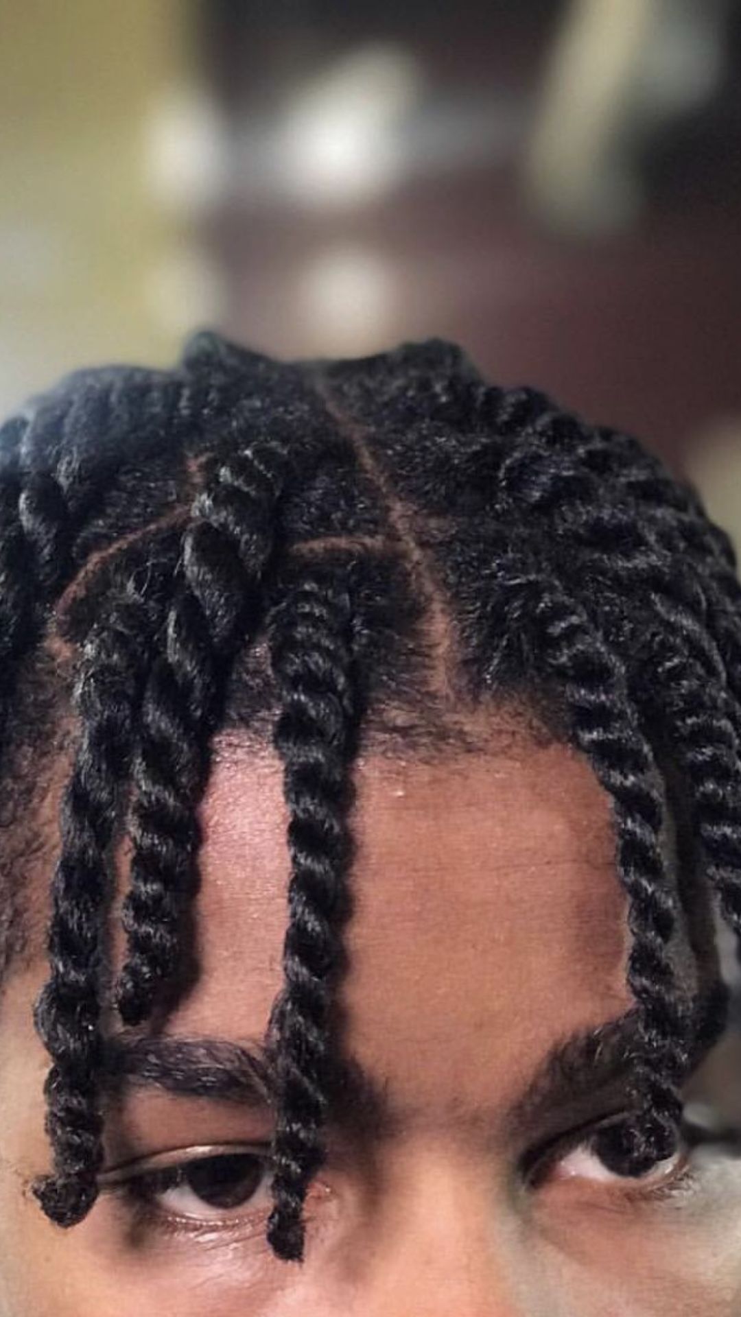 A man displaying a twist hairstyle, featuring elegant braids that enhance his overall look.