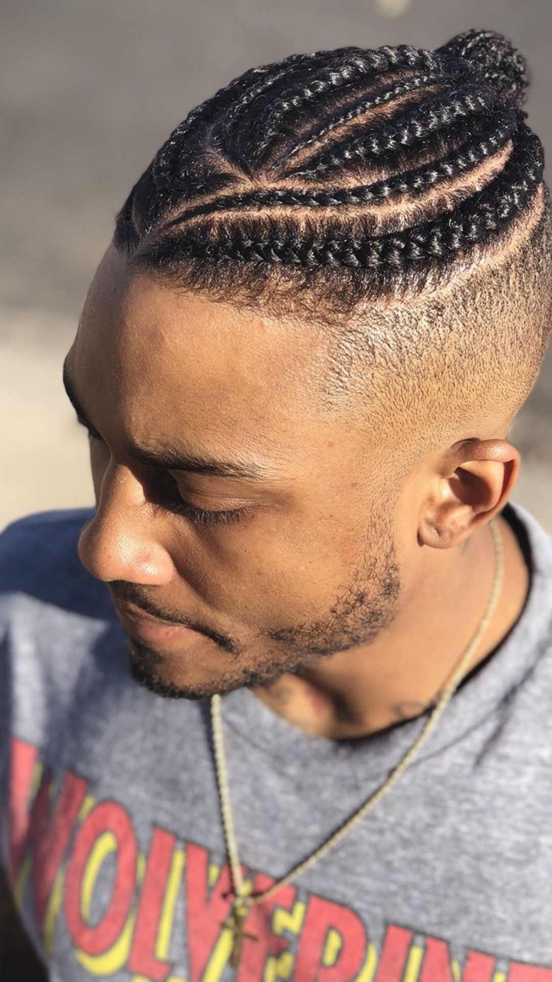 A man with a neatly styled braid in his hair, exemplifying contemporary braid hairstyles.