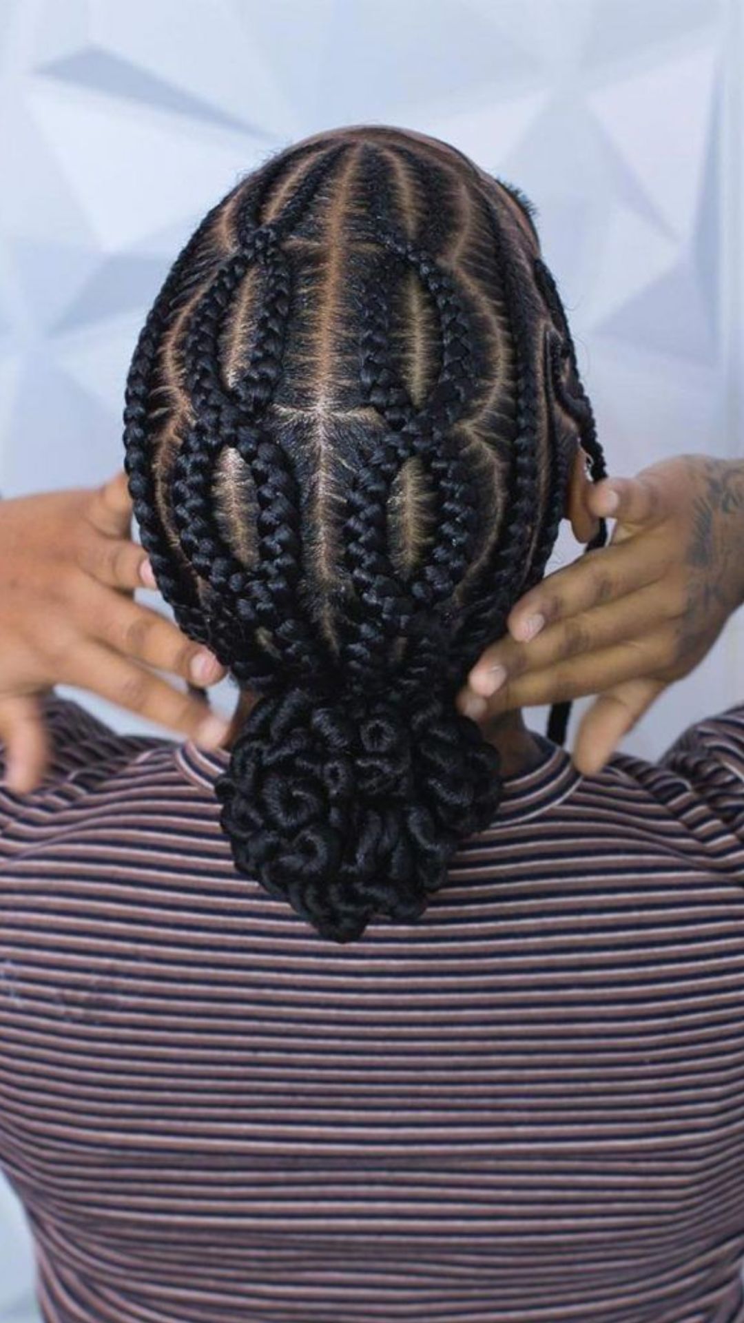 A woman with her hair styled in a bun, showcasing intricate braid hairstyles around her head.