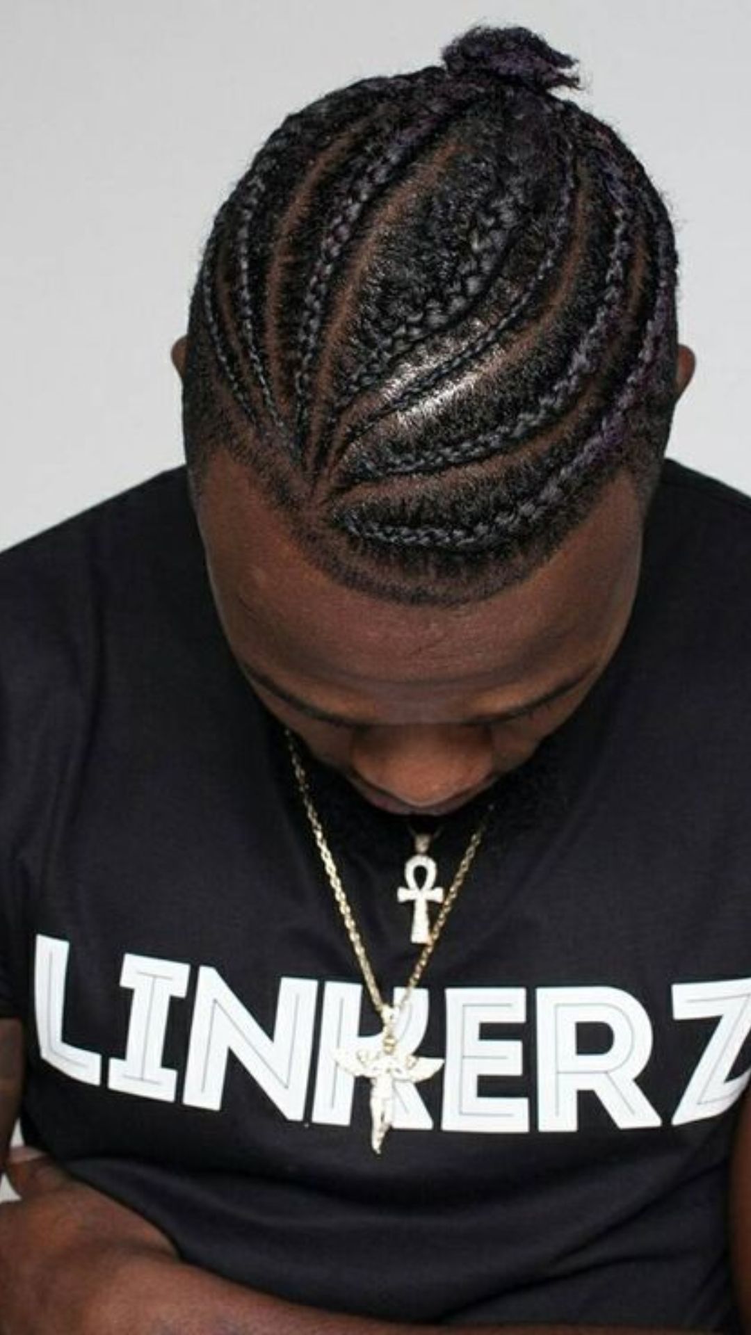 A man with braided hair, displaying a fashionable and unique braid hairstyle that highlights his individuality.