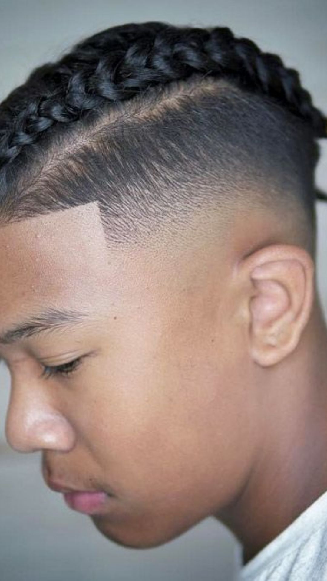 A young man with a neatly styled braid in his hair, exemplifying contemporary braid hairstyles.