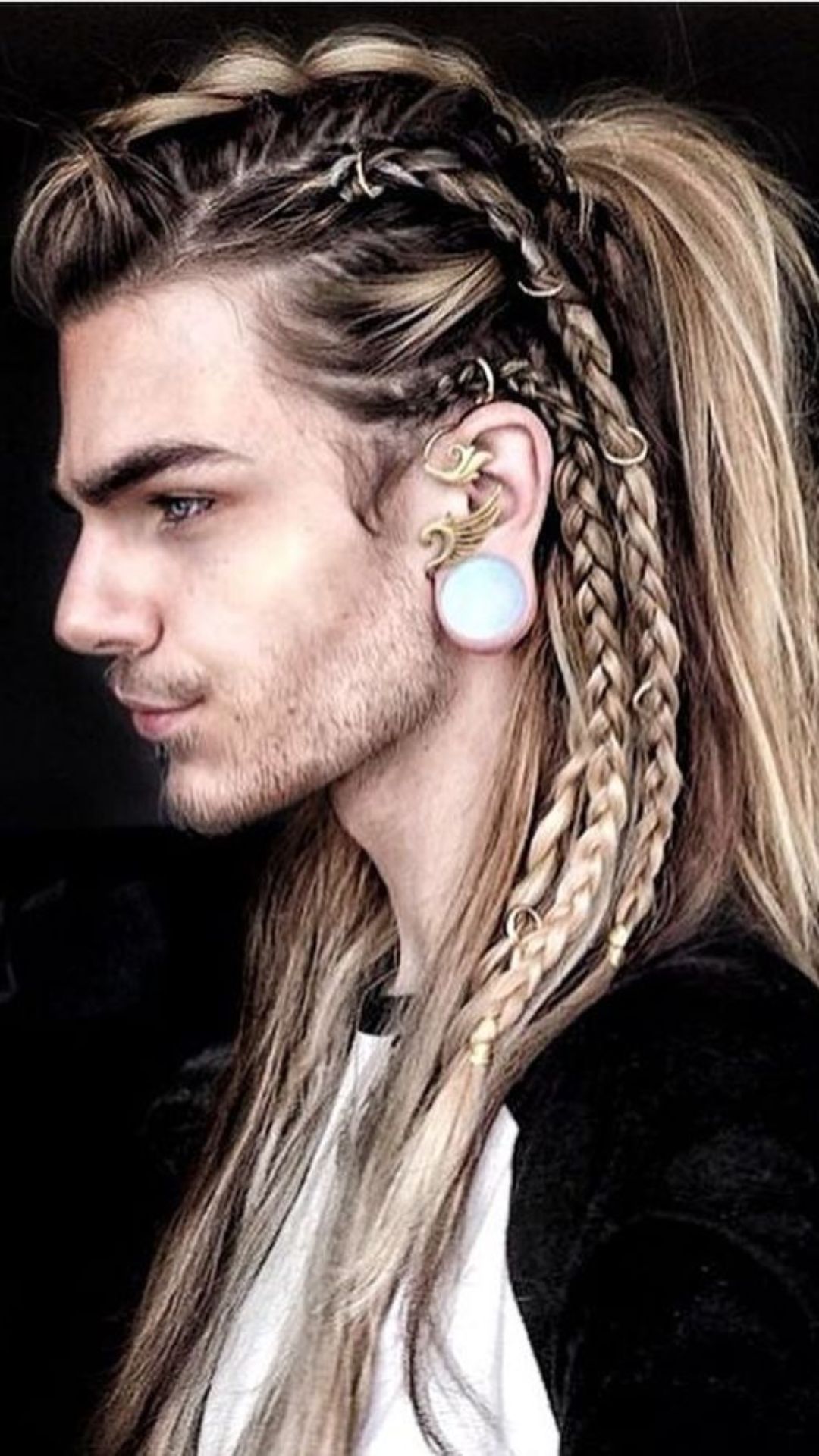 A man with long hair tied in a ponytail, featuring intricate braid details that enhance his stylish appearance.