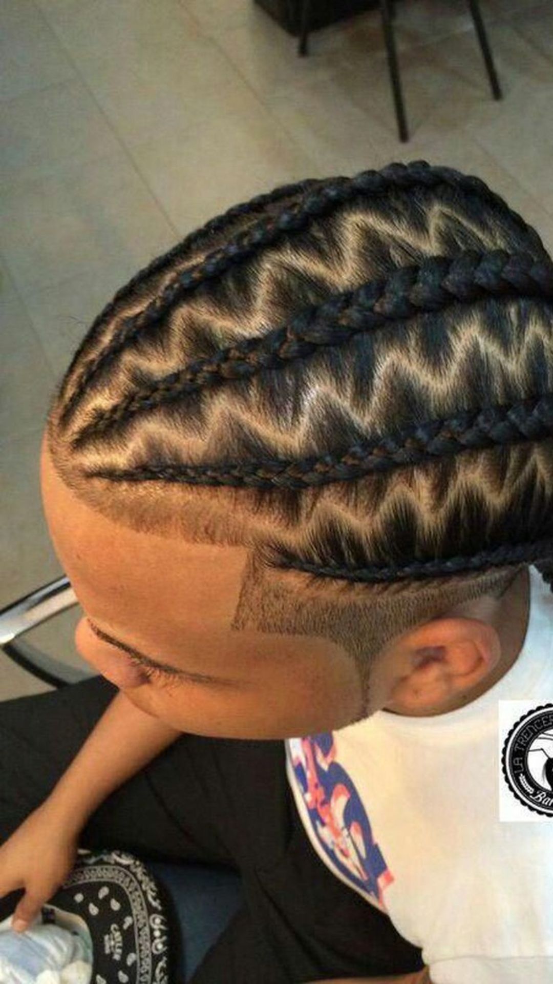 A man displaying a fashionable braided hairdo, illustrating the creativity of braid hairstyles.